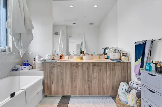 a bathroom with a sink mirror and a bathtub