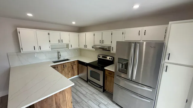 a kitchen with white cabinets and stainless steel appliances