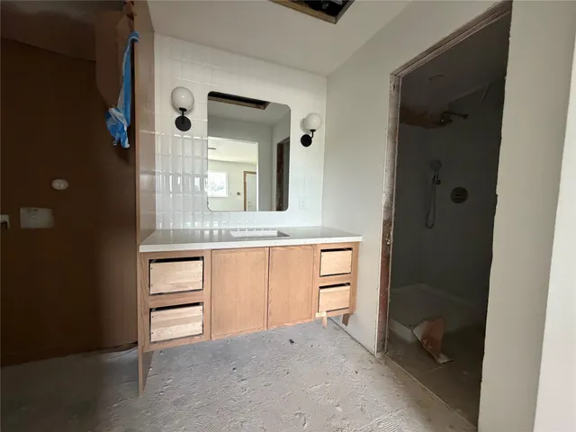 a bathroom with a granite countertop sink and a mirror