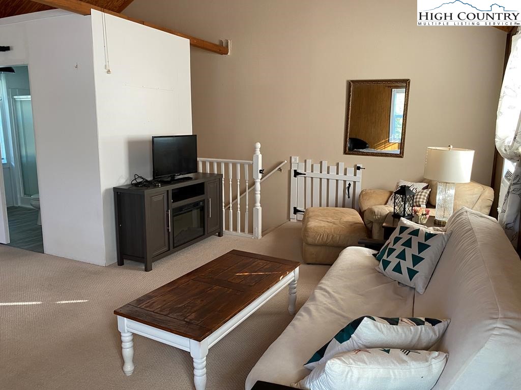 562 Nikanor Road, Unit UPPER LEVEL SUITE West Jefferson, NC 28694 - Photo 4 of 11 a living room with furniture and a flat screen tv