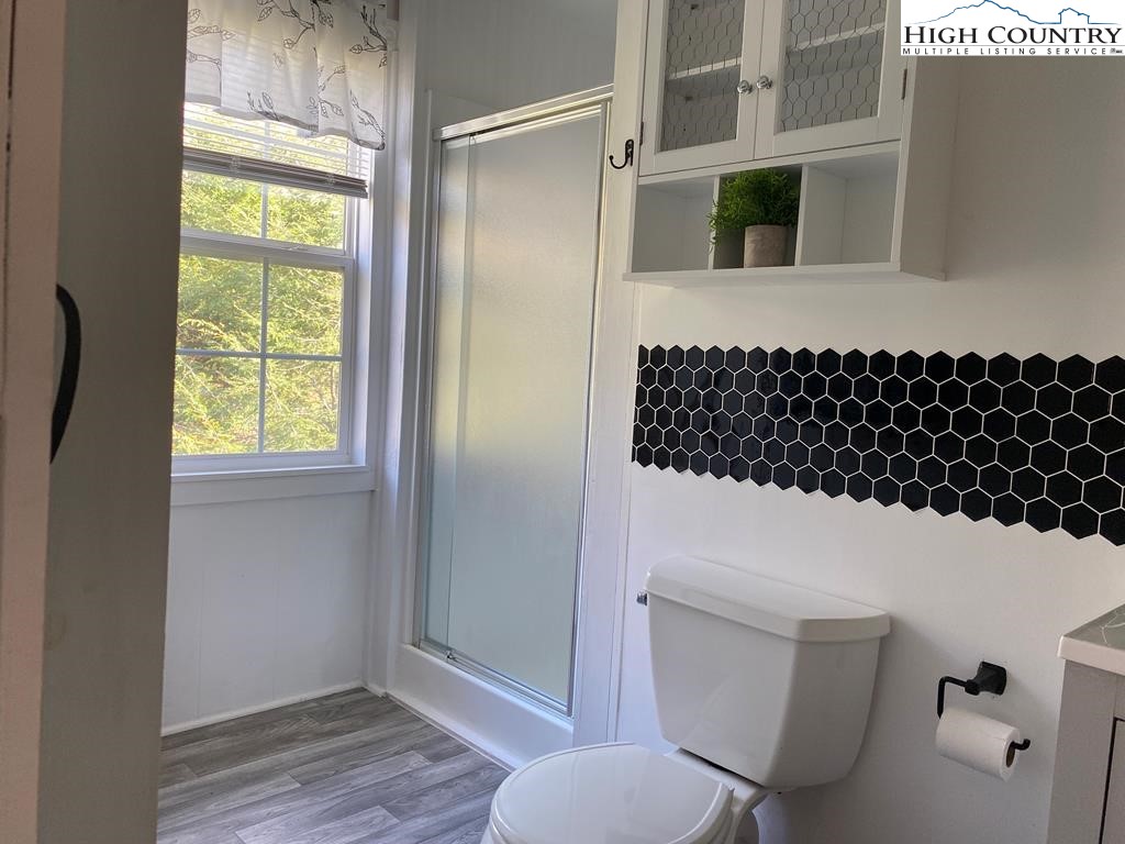 562 Nikanor Road, Unit UPPER LEVEL SUITE West Jefferson, NC 28694 - Photo 10 of 11 a bathroom with a toilet a sink and a window