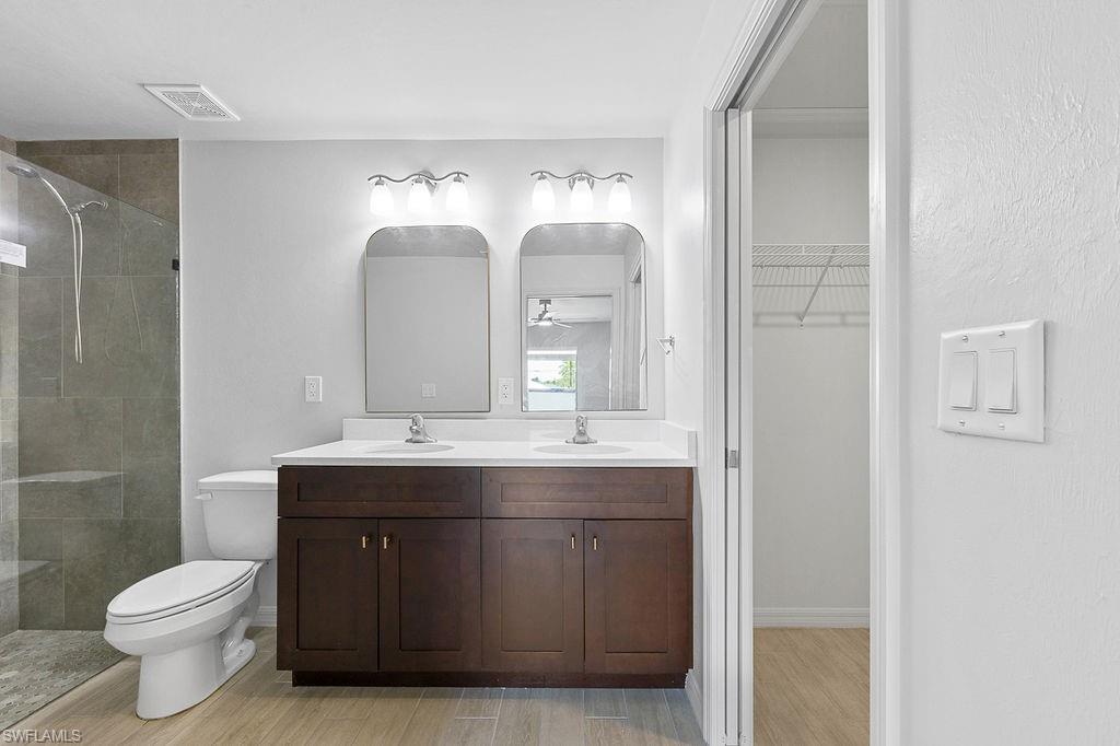 3429 Southwest 8th Place Cape Coral, FL 33914 - Photo 15 of 19 a bathroom with a double vanity sink toilet and a mirror