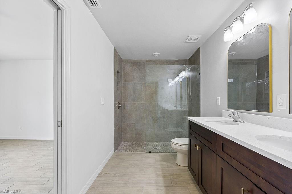 3429 Southwest 8th Place Cape Coral, FL 33914 - Photo 16 of 19 a bathroom with a double vanity sink toilet and shower