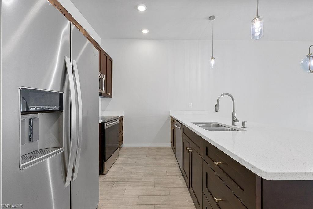 3429 Southwest 8th Place Cape Coral, FL 33914 - Photo 6 of 19 a kitchen with stainless steel appliances granite countertop a refrigerator and a sink