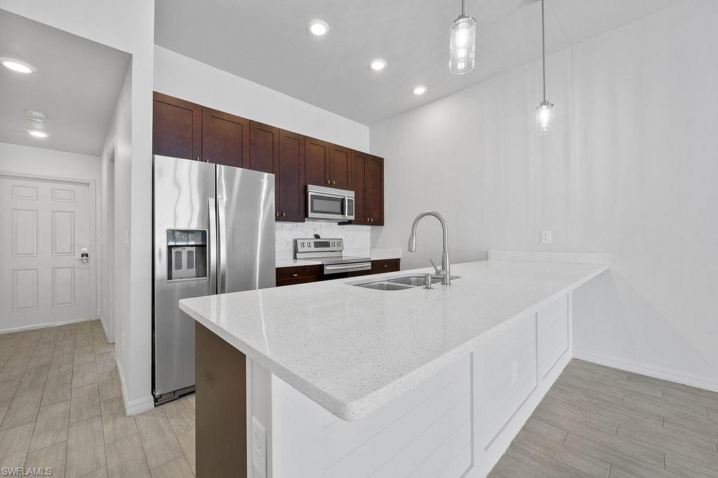 3429 Southwest 8th Place Cape Coral, FL 33914 - Photo 7 of 19 a kitchen with stainless steel appliances a refrigerator sink and microwave