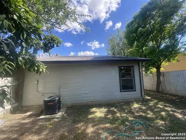 a view of a yard with plants and trees