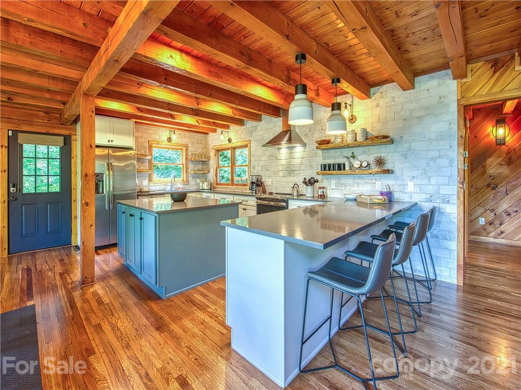 1933 Laurel Ridge North Maggie Valley, NC 28751 - Photo 11 of 44 a kitchen with stainless steel appliances granite countertop a sink stove and wooden cabinets