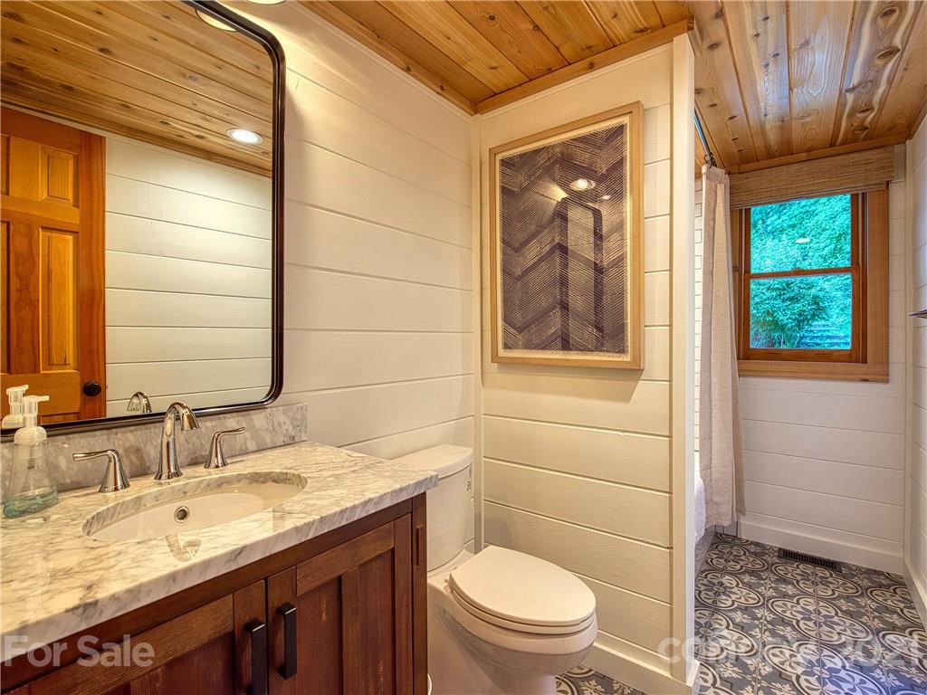 1933 Laurel Ridge North Maggie Valley, NC 28751 - Photo 24 of 44 a bathroom with a granite countertop sink toilet and painting on the wall
