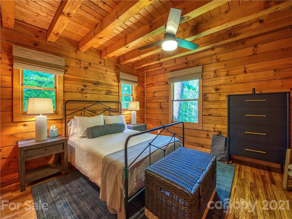 1933 Laurel Ridge North Maggie Valley, NC 28751 - Photo 25 of 44 a bedroom with a bed and a dresser next to a window