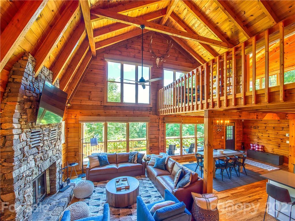 1933 Laurel Ridge North Maggie Valley, NC 28751 - Photo 6 of 44 a living room with furniture a fireplace and floor to ceiling windows