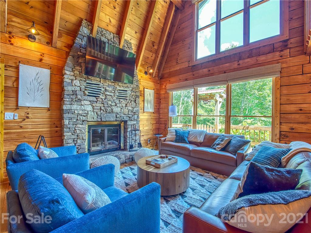 1933 Laurel Ridge North Maggie Valley, NC 28751 - Photo 7 of 44 a living room with furniture a fireplace and floor to ceiling windows