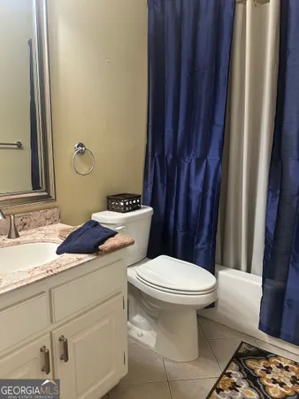 a bathroom with a sink a toilet a mirror and shower curtain