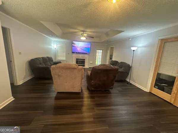 a living room with furniture a fireplace a flat screen tv and a window