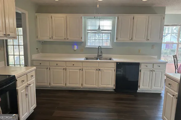 a kitchen with stainless steel appliances granite countertop a sink a stove a refrigerator and cabinets