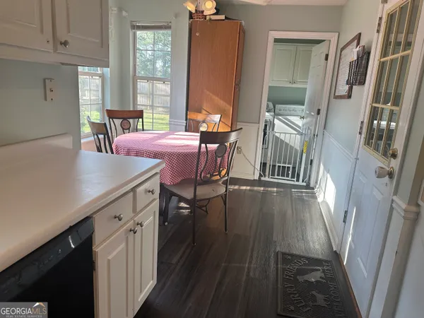 a kitchen with sink a refrigerator and chairs