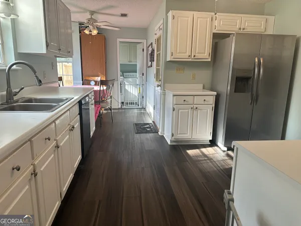 a kitchen with stainless steel appliances a sink dishwasher a refrigerator a stove oven with wooden floor