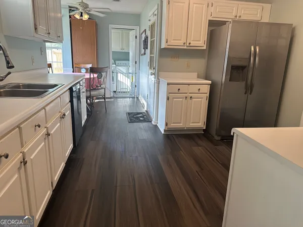a kitchen with a sink a refrigerator a stove and wooden floor