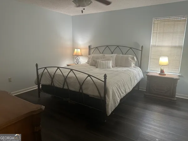 a bedroom with a bed and a lamp on dresser