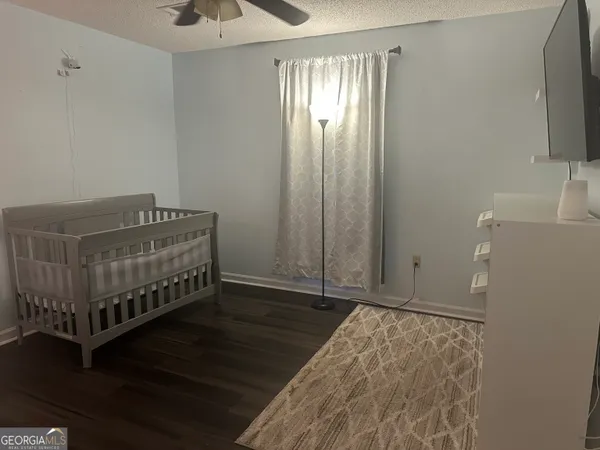 a bedroom with a bed and a chandelier fan