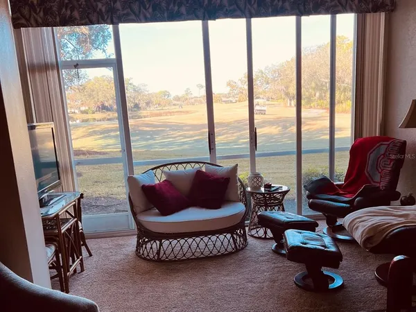 a living room with furniture and a floor to ceiling window