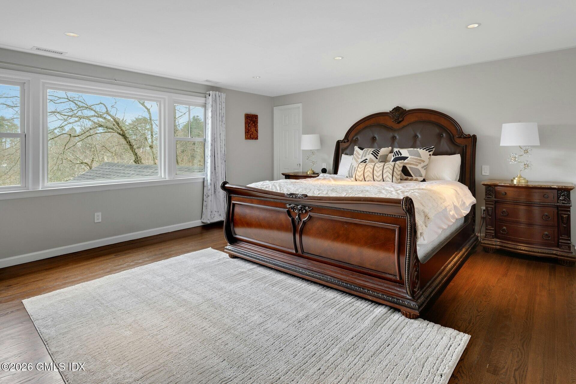 83 Burning Tree Road Greenwich, CT 06830 - Photo 13 of 26 a bedroom with a bed a window and wooden floor