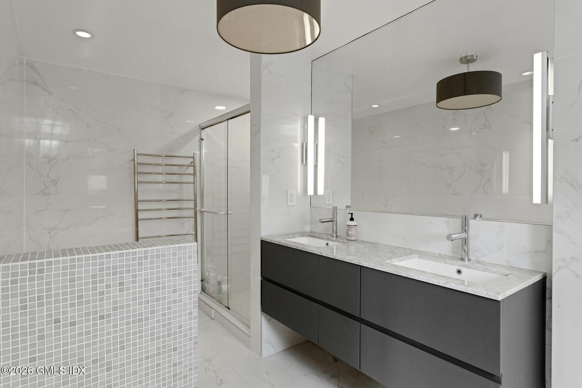 83 Burning Tree Road Greenwich, CT 06830 - Photo 14 of 26 a bathroom with a double vanity sink a mirror and a shower