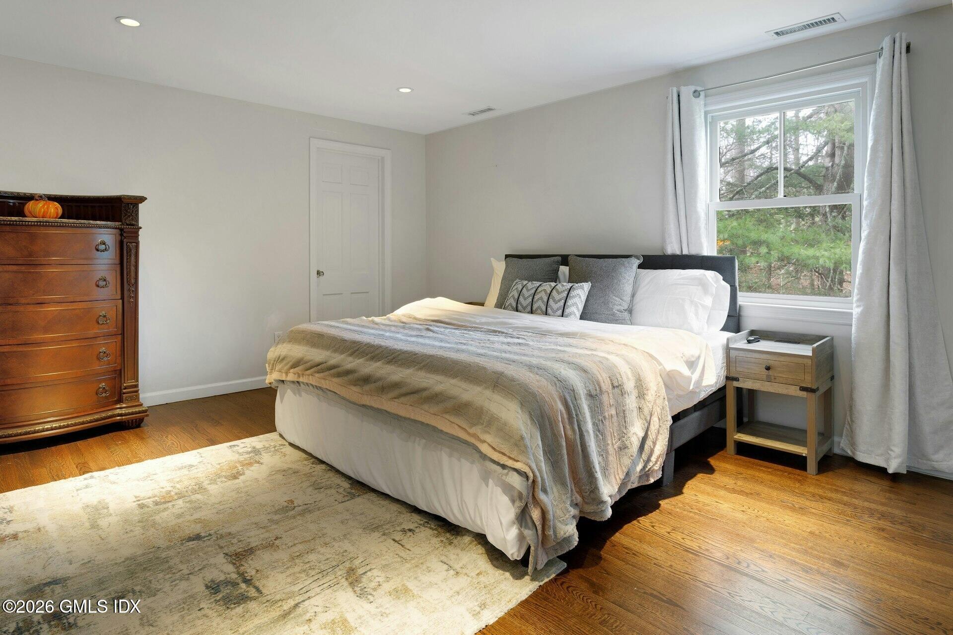 83 Burning Tree Road Greenwich, CT 06830 - Photo 15 of 26 a bed room with a bed and a window