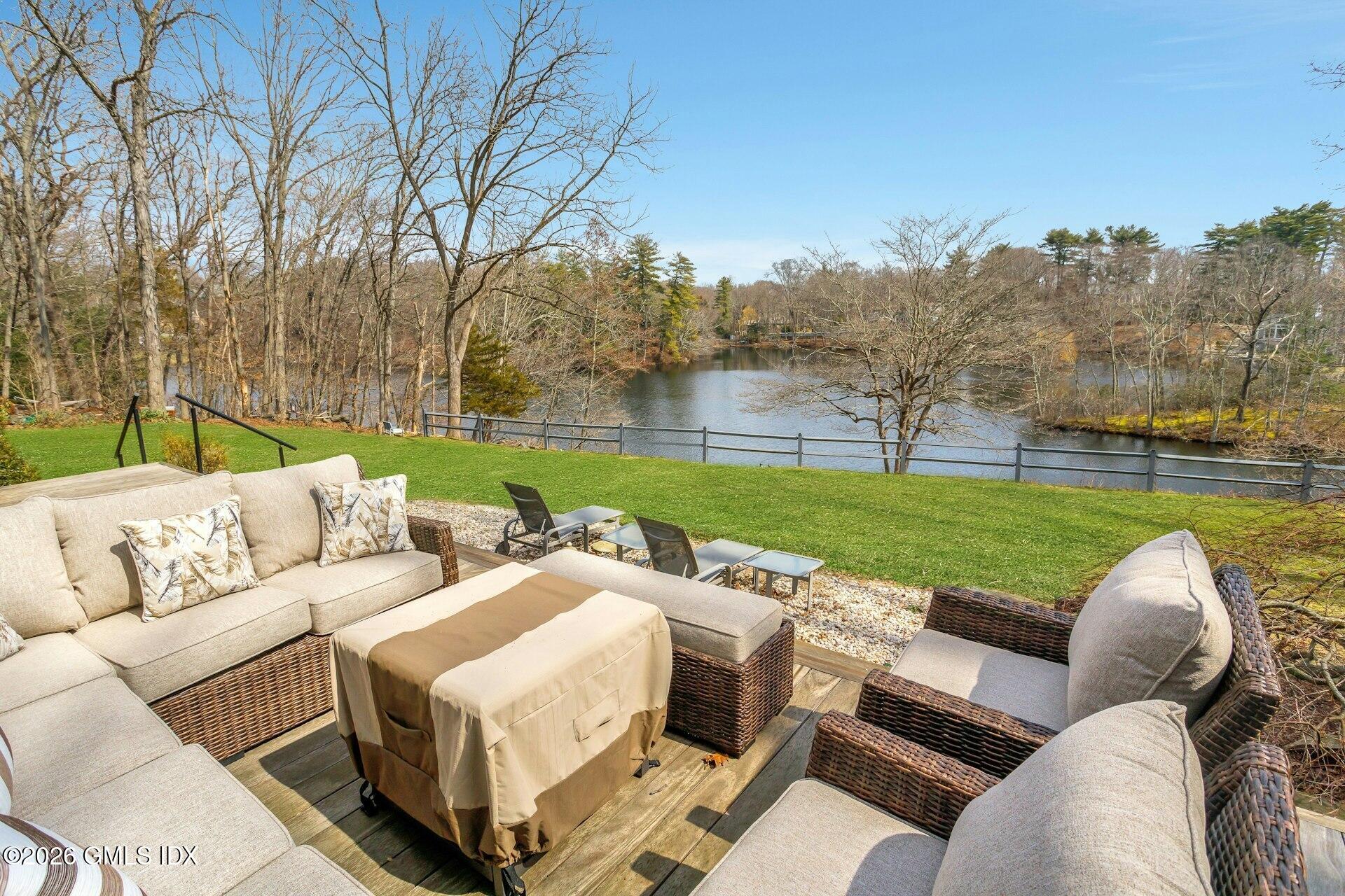 83 Burning Tree Road Greenwich, CT 06830 - Photo 19 of 26 a view of a yard with furniture and a lake view