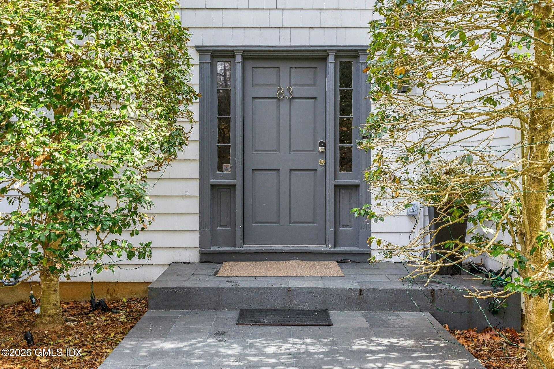 83 Burning Tree Road Greenwich, CT 06830 - Photo 2 of 26 a front view of a house with a garden