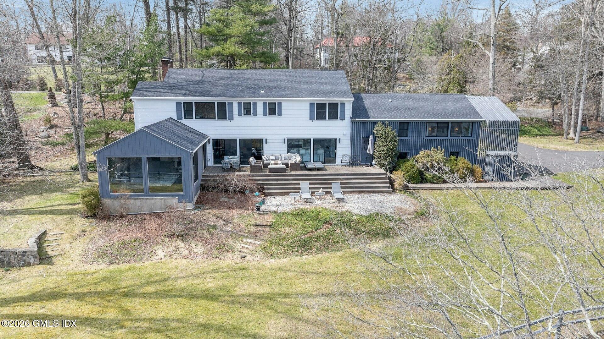 83 Burning Tree Road Greenwich, CT 06830 - Photo 22 of 26 a front view of a house with a yard outdoor seating and garage