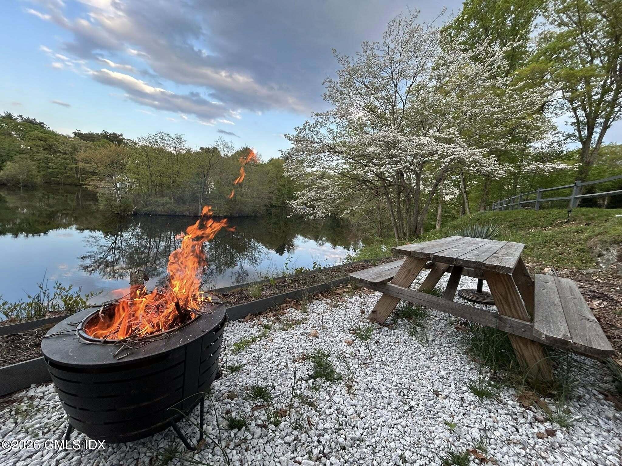 83 Burning Tree Road Greenwich, CT 06830 - Photo 25 of 26 a view of a backyard with water fountain and a lake view