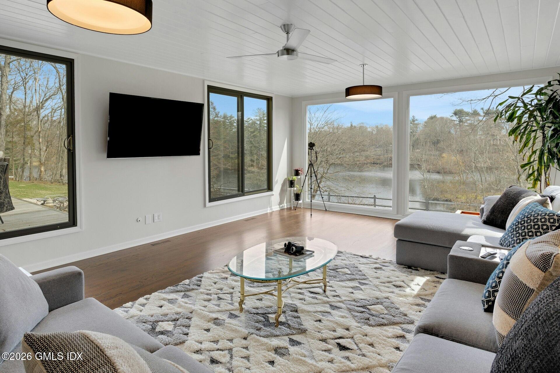 83 Burning Tree Road Greenwich, CT 06830 - Photo 6 of 26 a living room with furniture a flat screen tv and a large window