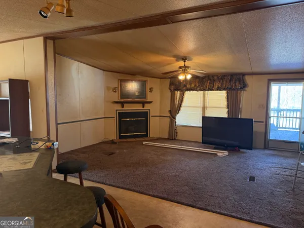a kitchen with stainless steel appliances granite countertop a table chairs and a refrigerator