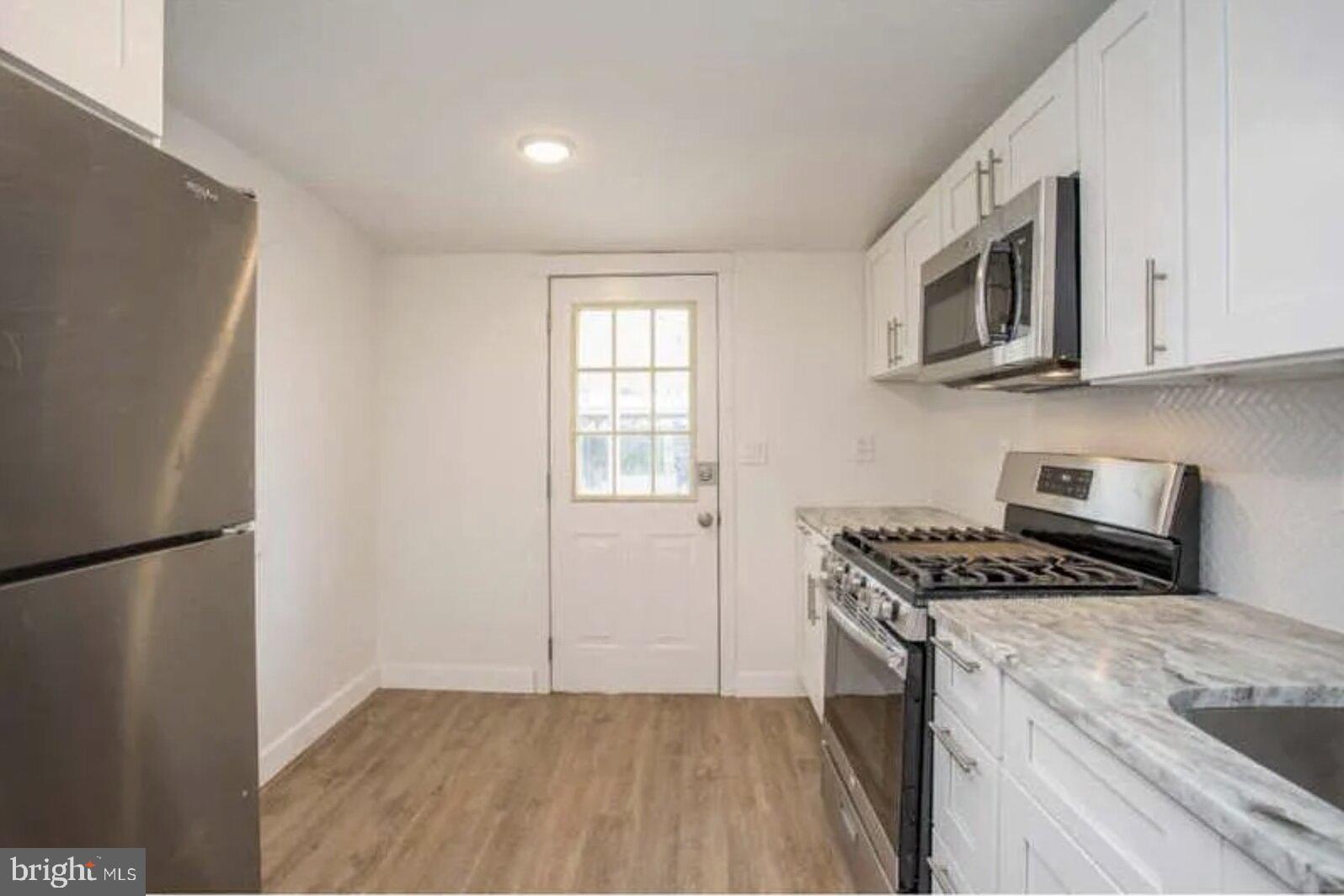 5 Coates Street Bridgeport, PA 19405 - Photo 3 of 28 a kitchen with stainless steel appliances granite countertop a refrigerator a stove a sink and a microwave