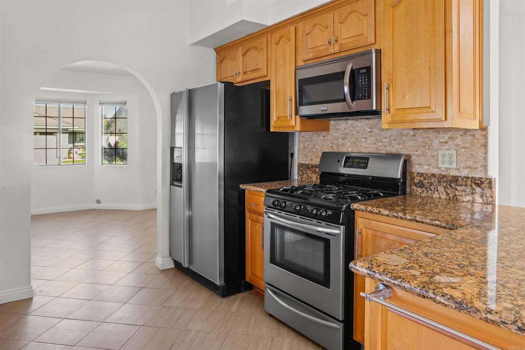 1387 Longfellow Road Vista, CA 92081 - Photo 12 of 38 a kitchen with granite countertop cabinets stainless steel appliances and a window