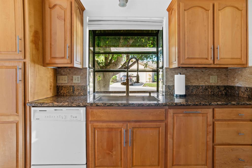 1387 Longfellow Road Vista, CA 92081 - Photo 13 of 38 a kitchen with granite countertop white cabinets and a window