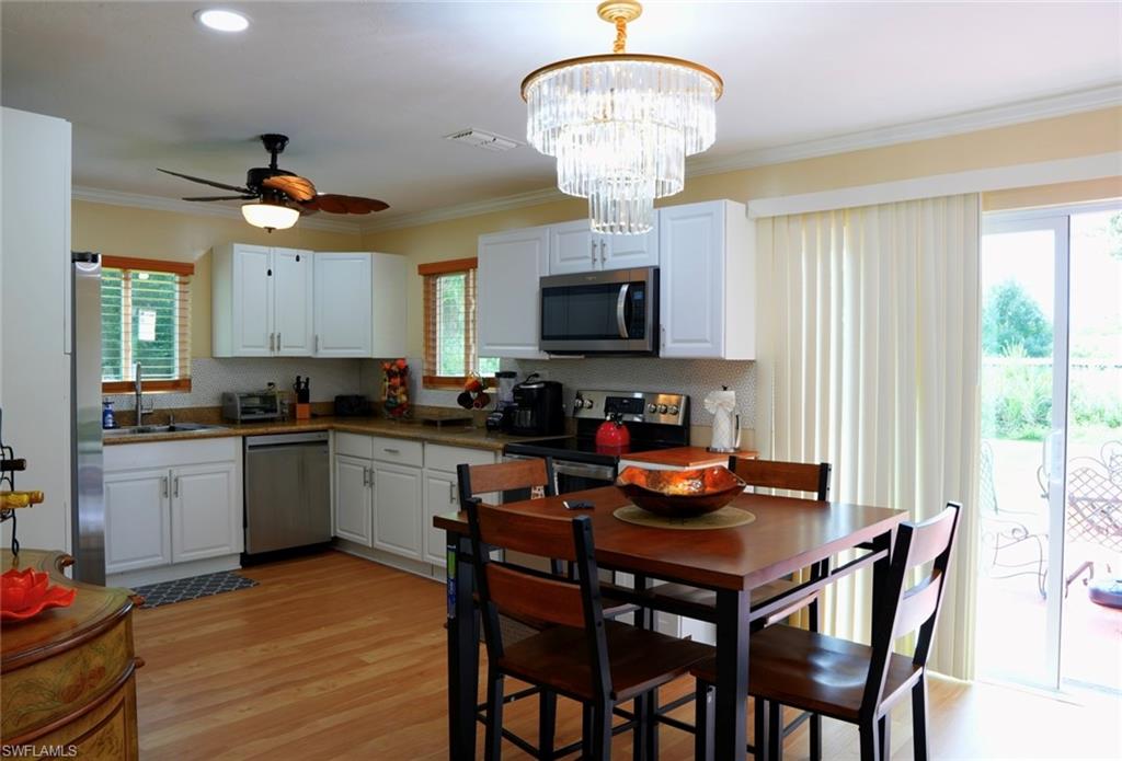 931 20th Street Southeast Naples, FL 34117 - Photo 7 of 21 a kitchen with a dining table chairs stainless steel appliances and cabinets