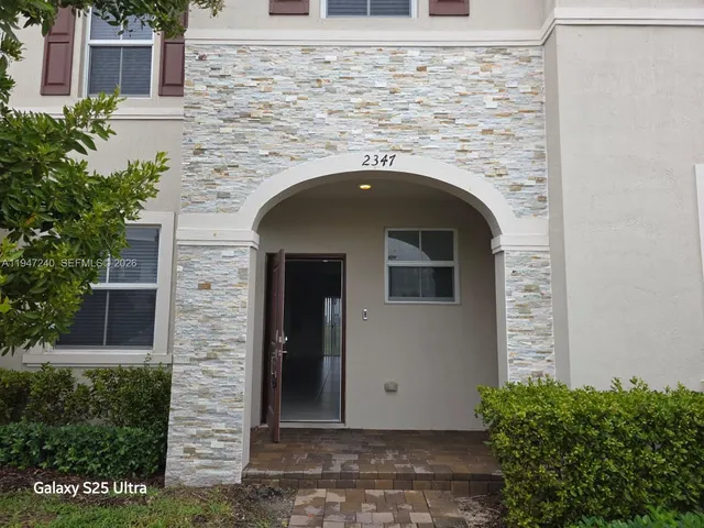 a front view of a house with plants