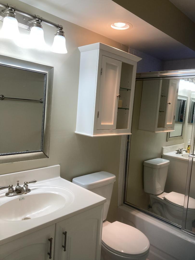 445 Saxony Way, Unit 445 Delray Beach, FL 33446 - Photo 6 of 10 a bathroom with a toilet a sink and mirror
