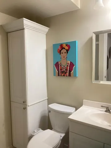 a white toilet sitting next to a bathroom sink