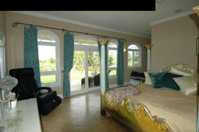 220 North Holokai Road Haiku, HI 96708 - Photo 14 of 29 a spacious bedroom with a bed and large windows