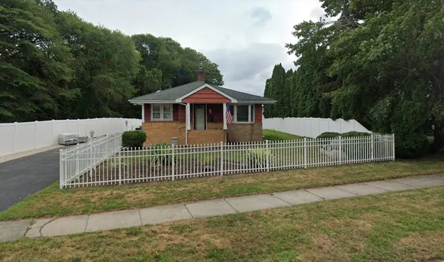 a view of a house with a yard and fence