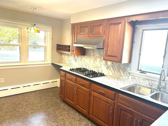 a bathroom with a granite countertop sink and a bathtub