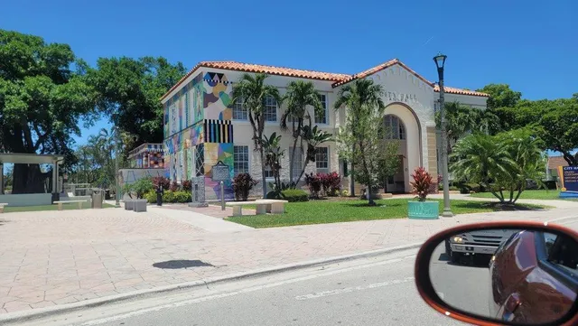 a view of a house with a yard and palm trees