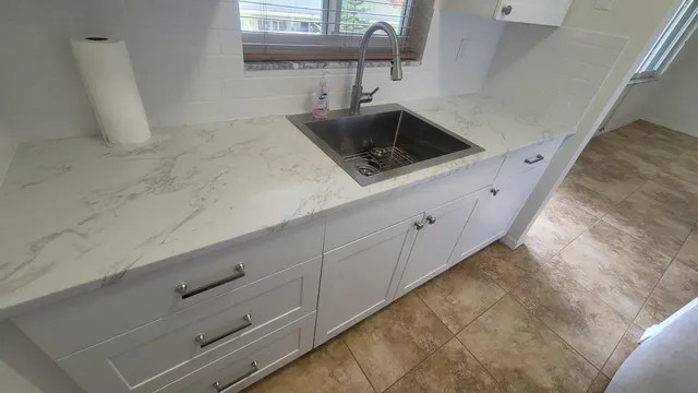 a kitchen with a sink a stove top oven and cabinets
