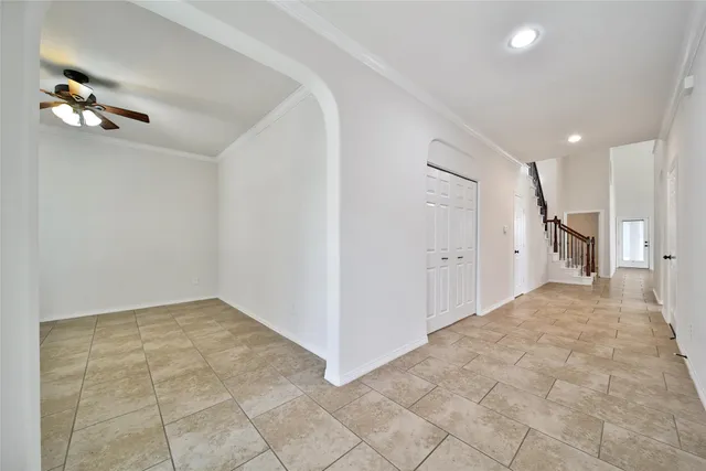 a view of a livingroom with a ceiling fan & entryway