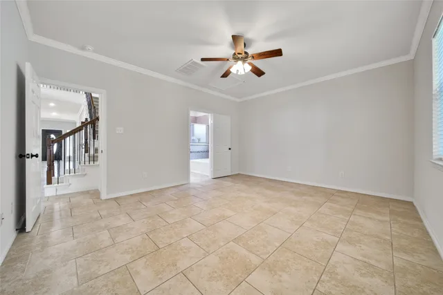 a view of a livingroom with a chandelier fan and windows