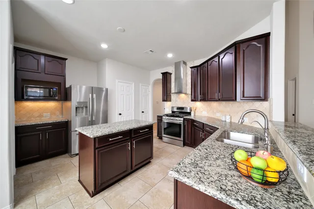 a kitchen with stainless steel appliances granite countertop a stove microwave and sink