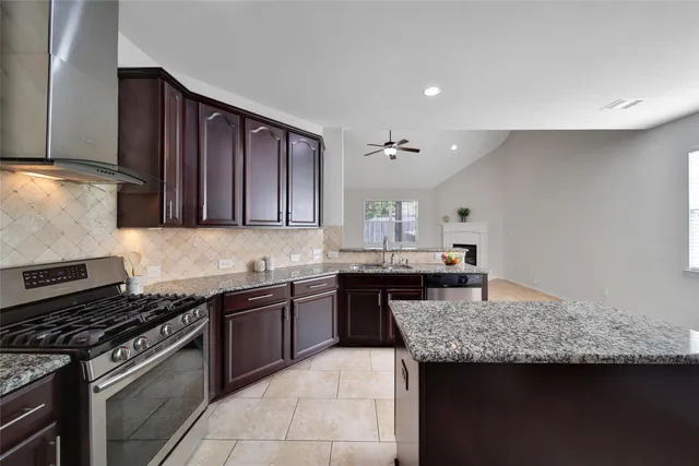 a kitchen with granite countertop stainless steel appliances and wooden cabinets