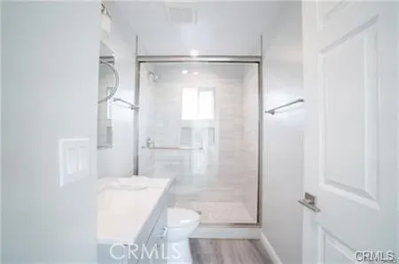 a bathroom with a sink toilet vanity and shower